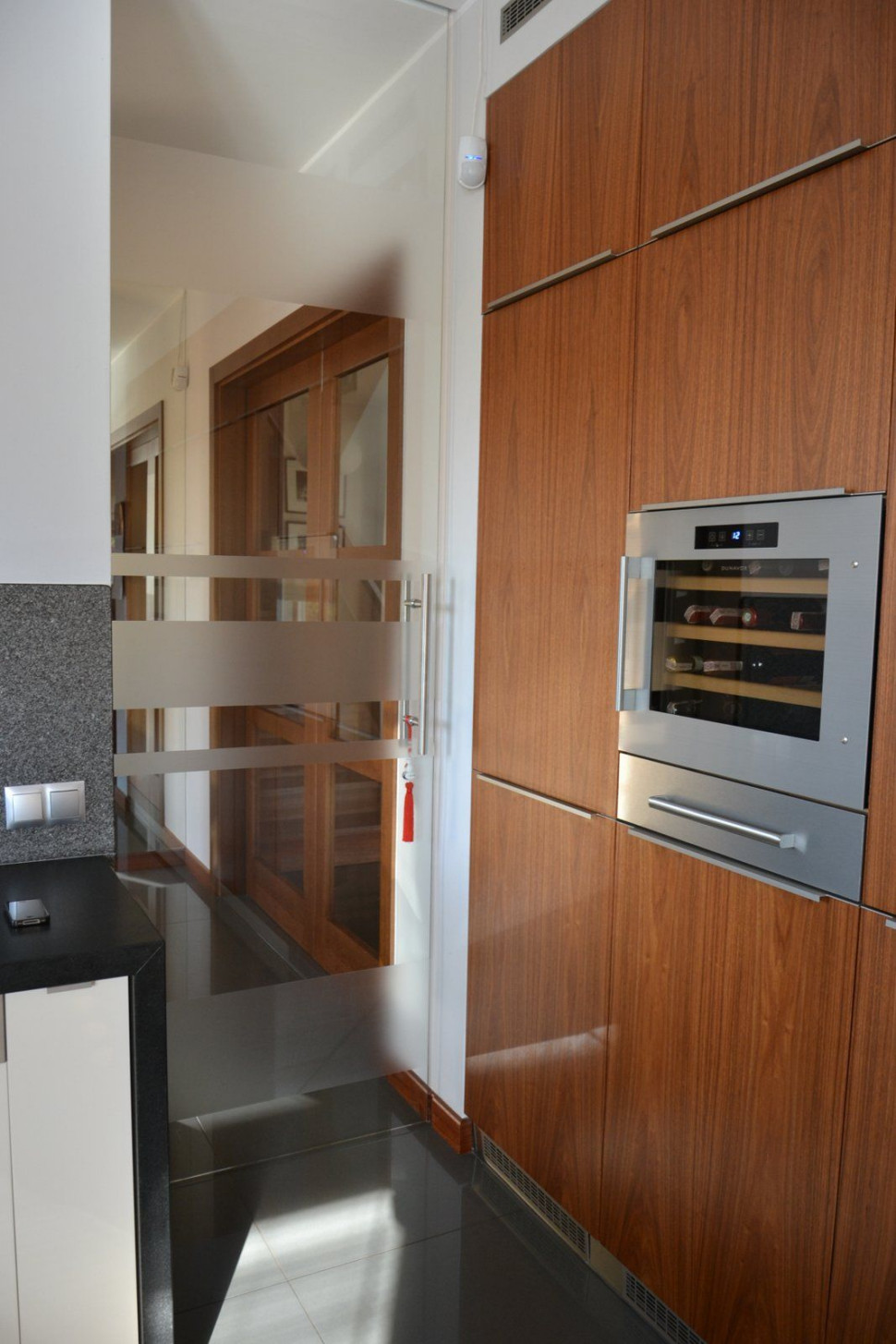 Przesuwne drzwi z hartowanego szkła o gr. 5 mm zastosowano między wiatrołapem i kuchnią