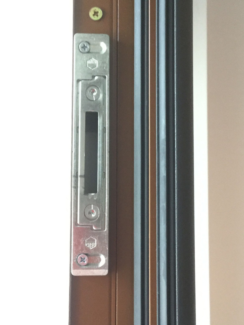 Elementy automatycznej zasuwnicy, ryglującej drzwi w 6 miejscach - m.in. zaczepy zasuwnicy z regulowanym dociskiem