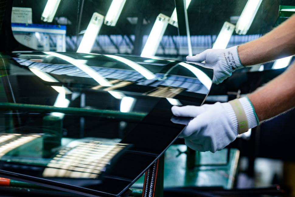 Szyba samochodowa w rękach operatora w hucie szkla. fot. NSG Group