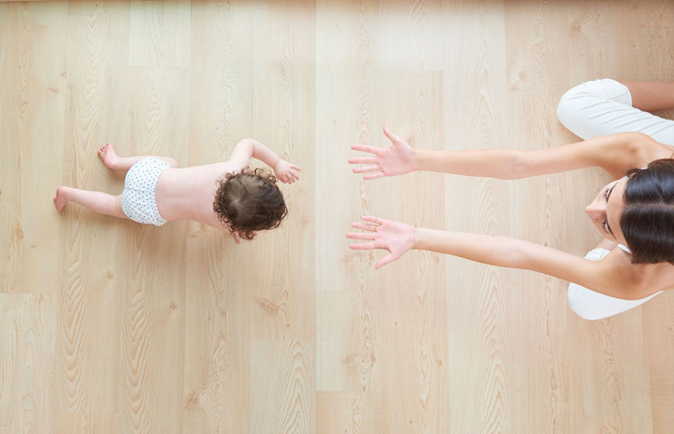 Małe dziecko z matką na podłodze warstwowej