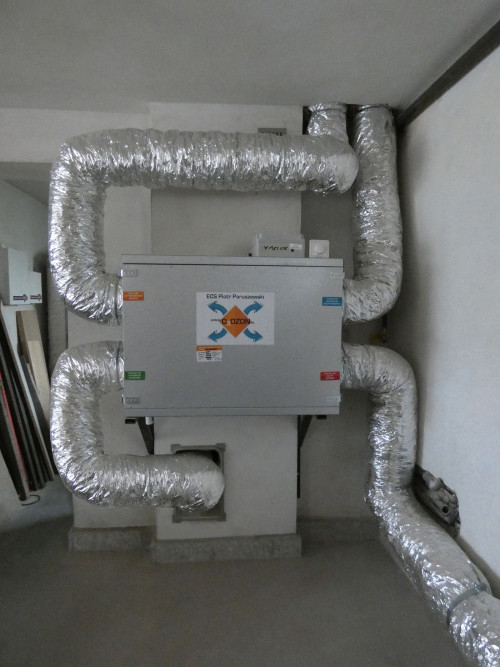 Centrala wentylacyjna w garażu i rura wyrzutni skierowana do przewodu wentylacyjnego w kominie