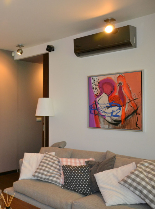 Ścienna jednostka klimatyzatora w czarnym kolorze wisi w salonie