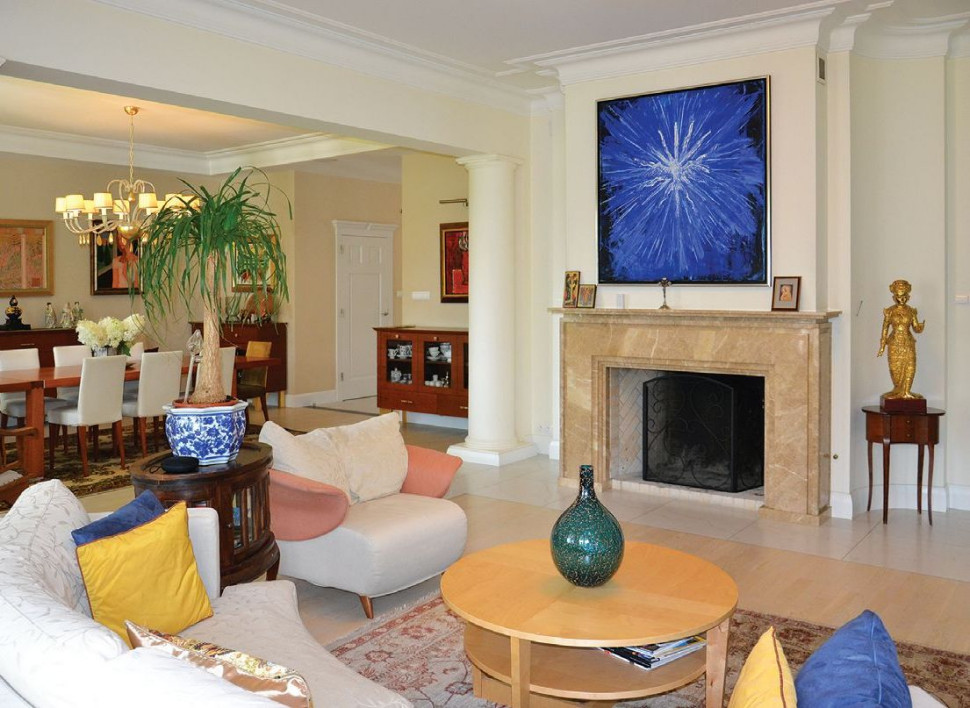 Salon z otwartym kominkiem łączy się z resztą pomieszczeń wspólnych