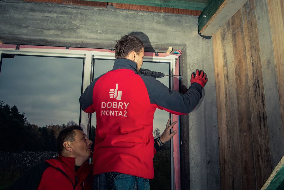Wypoziomowane okna mocuje się do muru. Zwrócimy uwagę na ucho (zakład taśmy) w górnym narożniku