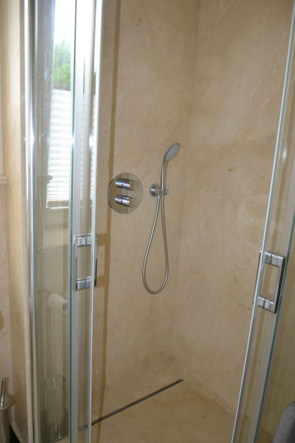 Minimalistyczny odpływ zamontowano w szklanej kabinie 90 x 90 cm