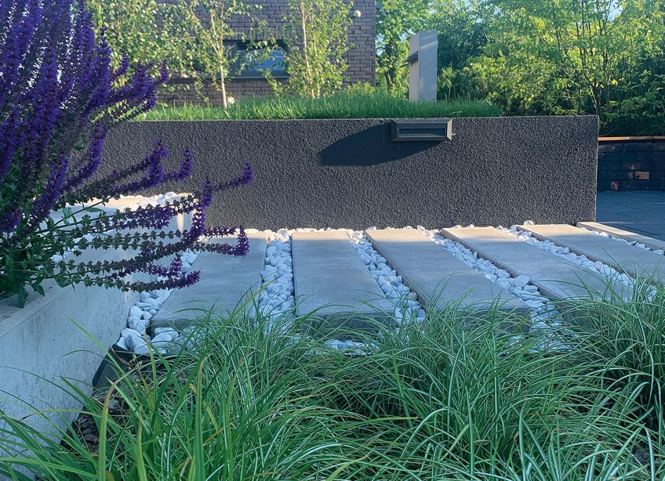 Jedna z minimalistycznych rabat, murek oporowy, kolorystyka taka, jak na elewacji