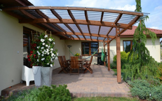 Zadaszenie tarasu o łukowatym kształcie, wykonane z drewna i przezroczystych z płyt poliwęglanu