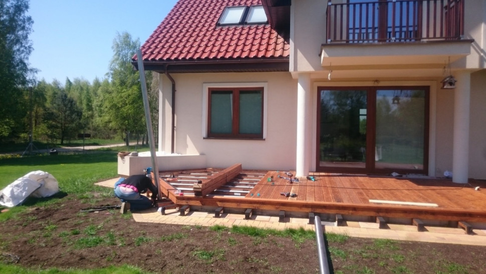 Układanie podestu z długich desek i montaż słupków ze stali nierdzewnej pod płócienny żagiel