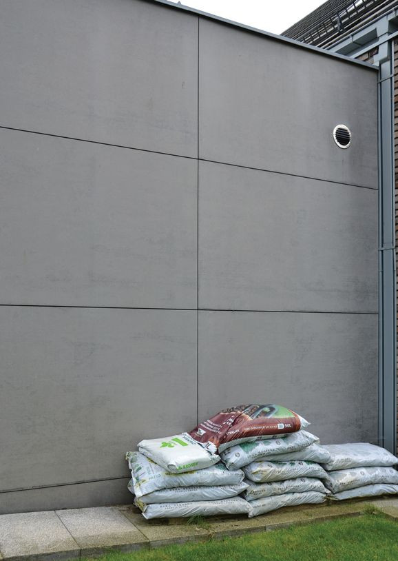 Faktura płyt na ścianie garażu imituje surowy porowaty beton