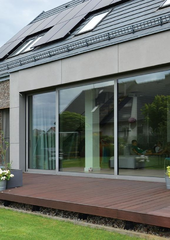 Faktura płyt na ścianie wykuszu przy tarasie imituje surowy porowaty beton