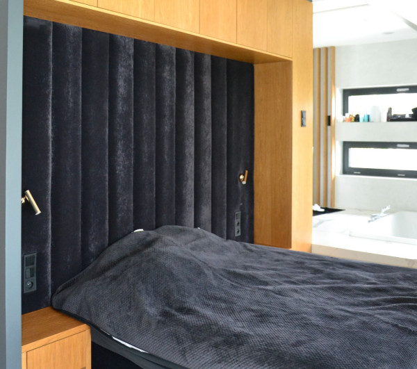 W sypialni - okładzina z fornirem dębowym, welurowy zagłówek