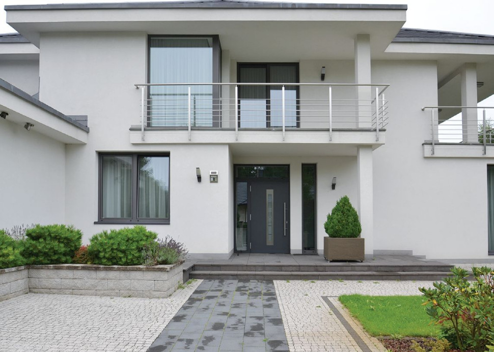 Dwukondygnacyjna bryła jest przykryta niskim kopertowym dachem z szerokimi okapami