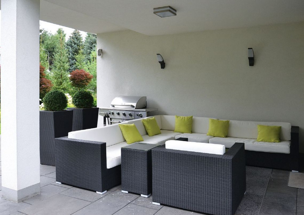 W zadaszonej części tarasu (4 × 4 m) właściciele postawili duży zestaw wypoczynkowy i przenośny grill