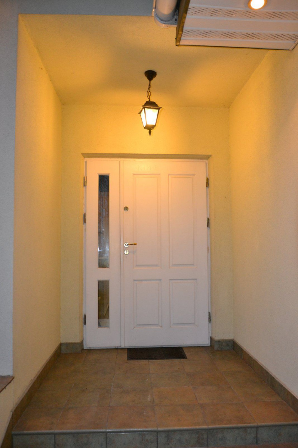 Wisząca lampa we wnęce nad gankiem