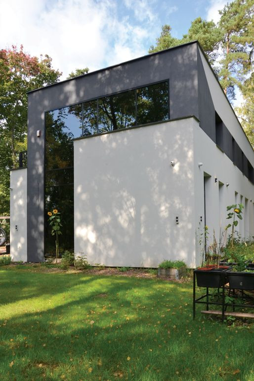 Ciemny pas tynku wywołuje wrażenie przedłużenia najbardziej spektakularnego przeszklenia fasadowego aż na całą tylną ścianę