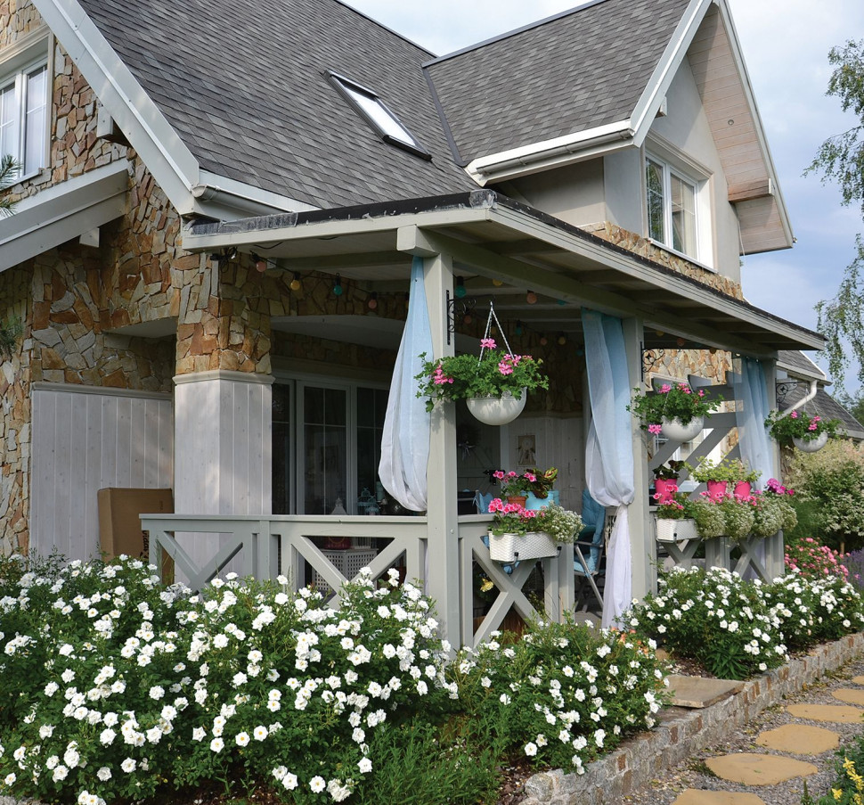 Zadaszony taras otoczony kwiatami