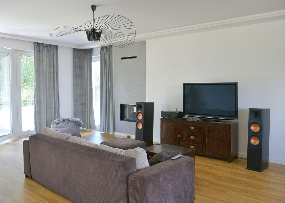 Połączona strefa dzienna (obejmująca salon, jadalnię i kuchnię) rozciąga się w centrum podłużnej bryły