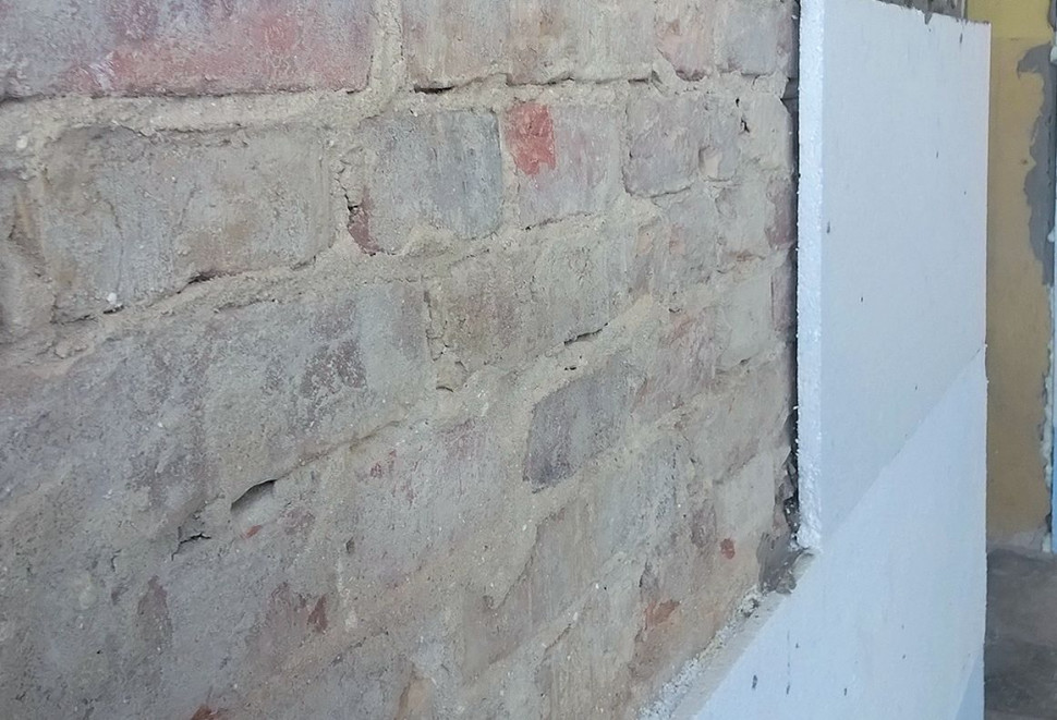 Przed przyklejeniem ocieplenia ściany należy oczyścić z odpadających fragmentów tynku i odpylić