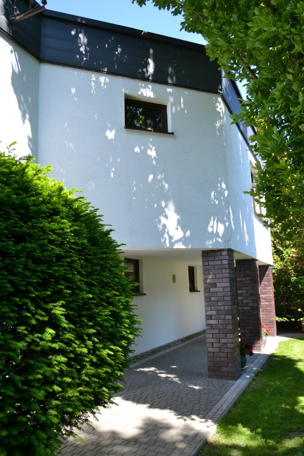 Dobudowane skrzydło wykończone tynkiem, okładziną z blachy i cegłą klinkierową