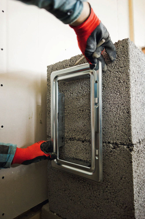 Montaż komina prefabrykowanego - krok 4. Należy w obudowie wyciąć otwory o wymiarach dostosowanych do drzwiczek wyczystki i króćców przyłączeniowych