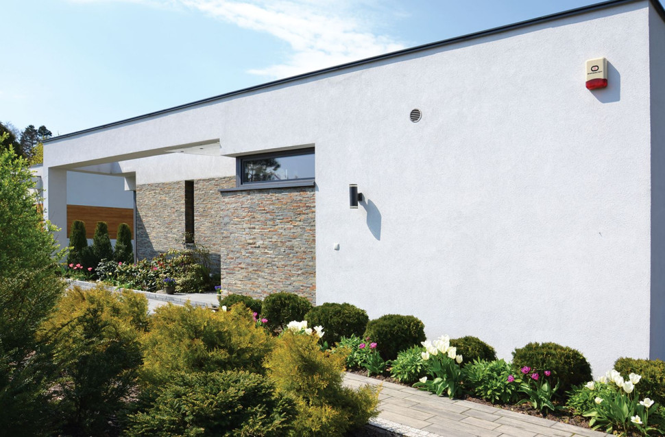 Elewacje zostały wykończone tynkiem silikonowym w kolorze białym i efektowną okładziną z łupka