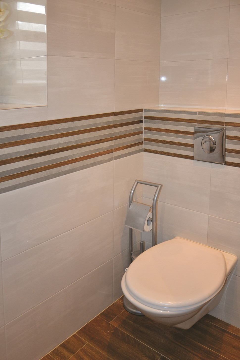 W posadzce wykonano podłogówkę, na ścianie z glazurą zamontowano podwieszany sedes