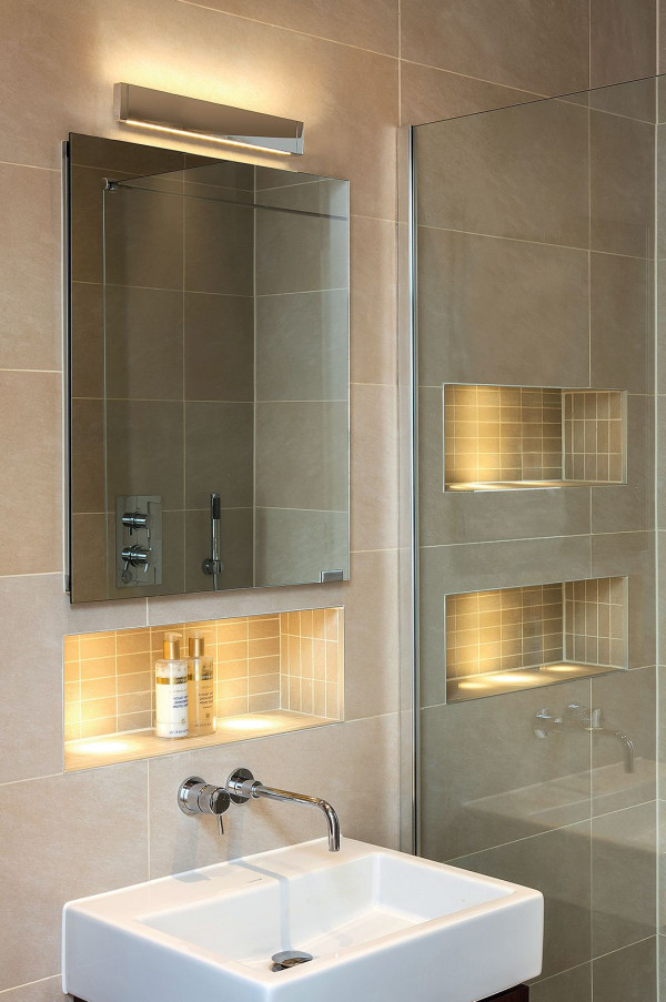 Kompozycja świetlna: nad lustrem kinkiet Astro Bergamo 600, półki wnękowe oświetlone taśmami ledowymi