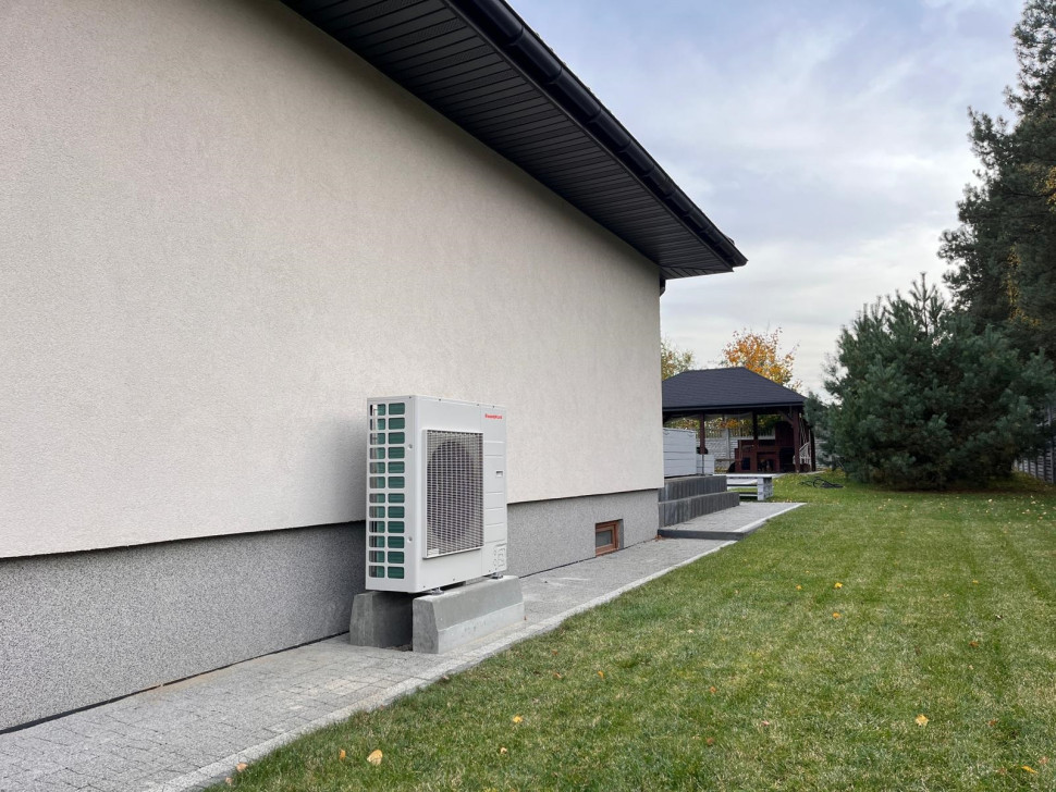 Jednostka zewnętrzna pompy ciepła przy ścianie domu jednorodzinnego