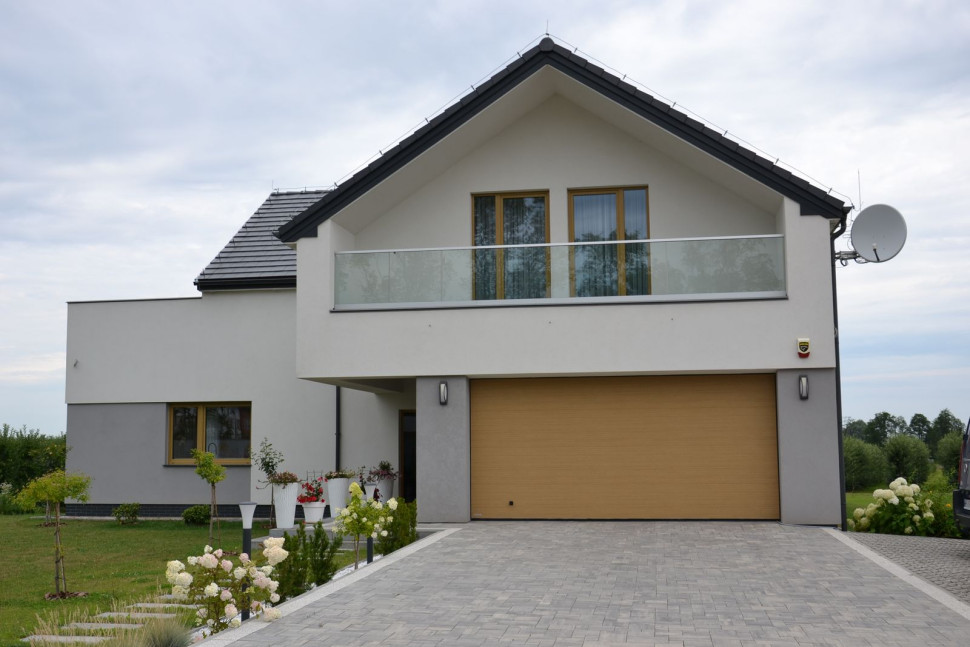 Na podjeździe ułożono bruk z betonu, na parkingu - ażurowe płyty