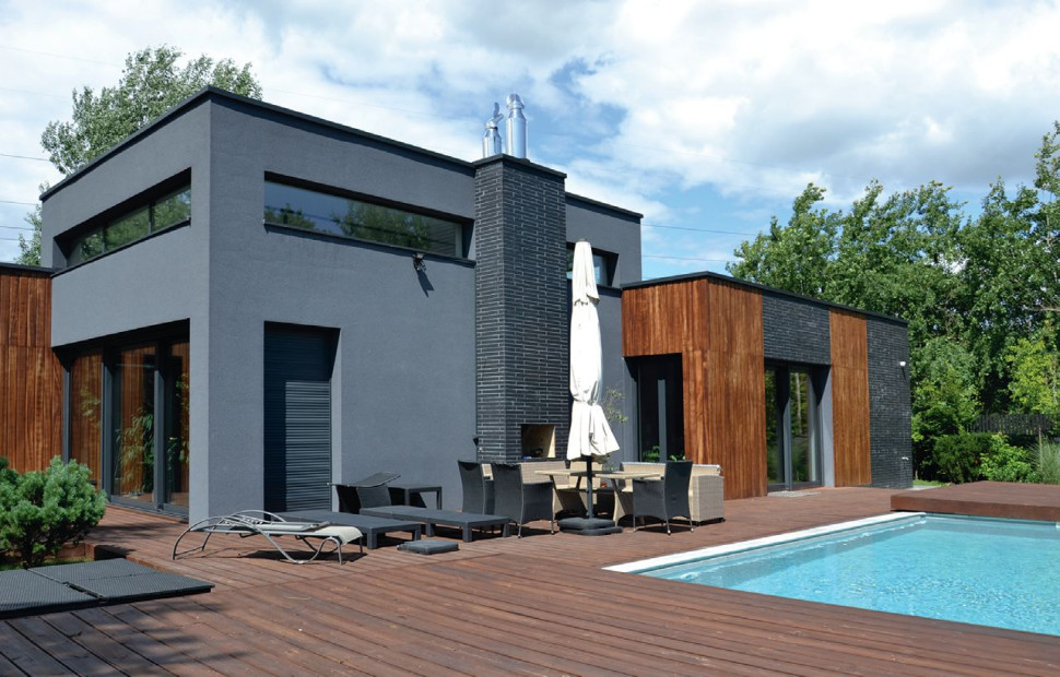 Rozłożysta, nieforemna bryła ma urozmaiconą wysokość - widok od strony ogrodu z basenem