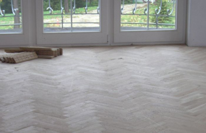 Układanie parkietu - krok 2) Klepki przykleja się zaczynając od okna i przesuwając się w głąb pomieszczenia