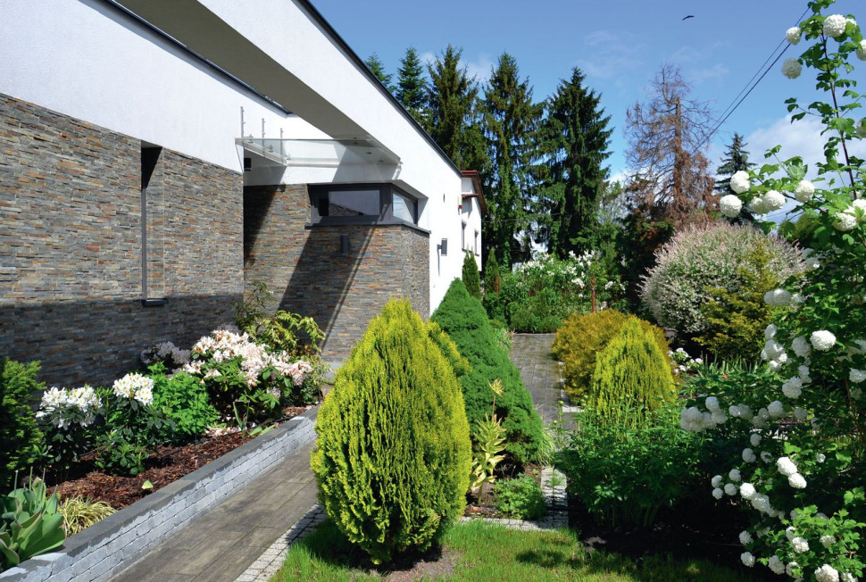 Przed frontem domu zastosowano roślinność mieszaną (iglasto-liściastą), żeby aranżacja była dekoracyjna przez cały rok