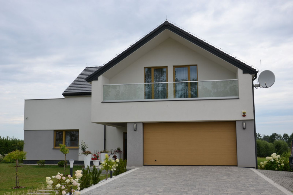 Dwuwarstwowy mur przykryto silikonowym tynkiem w odcieniu kremowym i szarym