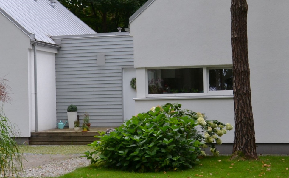 Ściany zewnętrzne: tynk silikatowy pomalowano białą farbą silikatową, okładzinę z termososny jasnoszarą bejcą