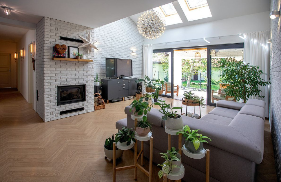 Światło dzienne wpada z góry do salonu (o wysokości dwóch kondygnacji) przez cztery okna dachowe