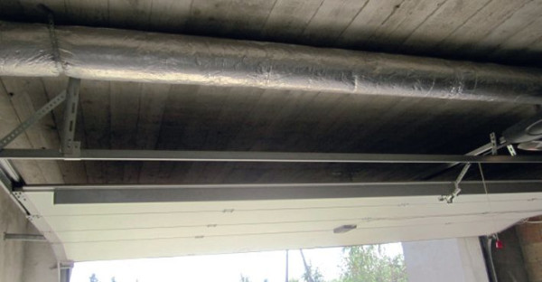 Szyny, po których brama wsuwa się pod strop garażu