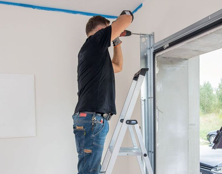 Przykręcanie elementu niezbędnego do montażu bramy garażowej