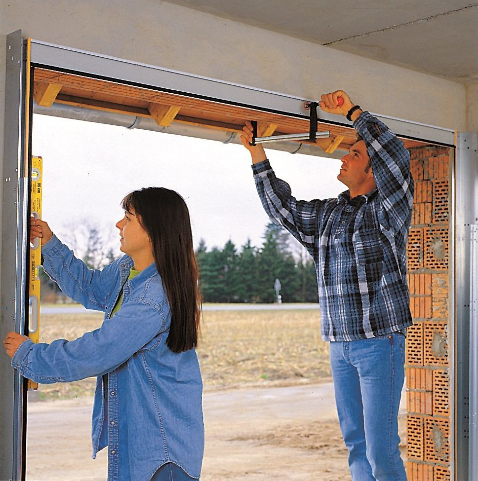 Montaż bramy segmentowej: Ramę skręconą z czterech profili ustawia się pionowo, dokładnie wyrównuje i unieruchamia w pozycji montażowej