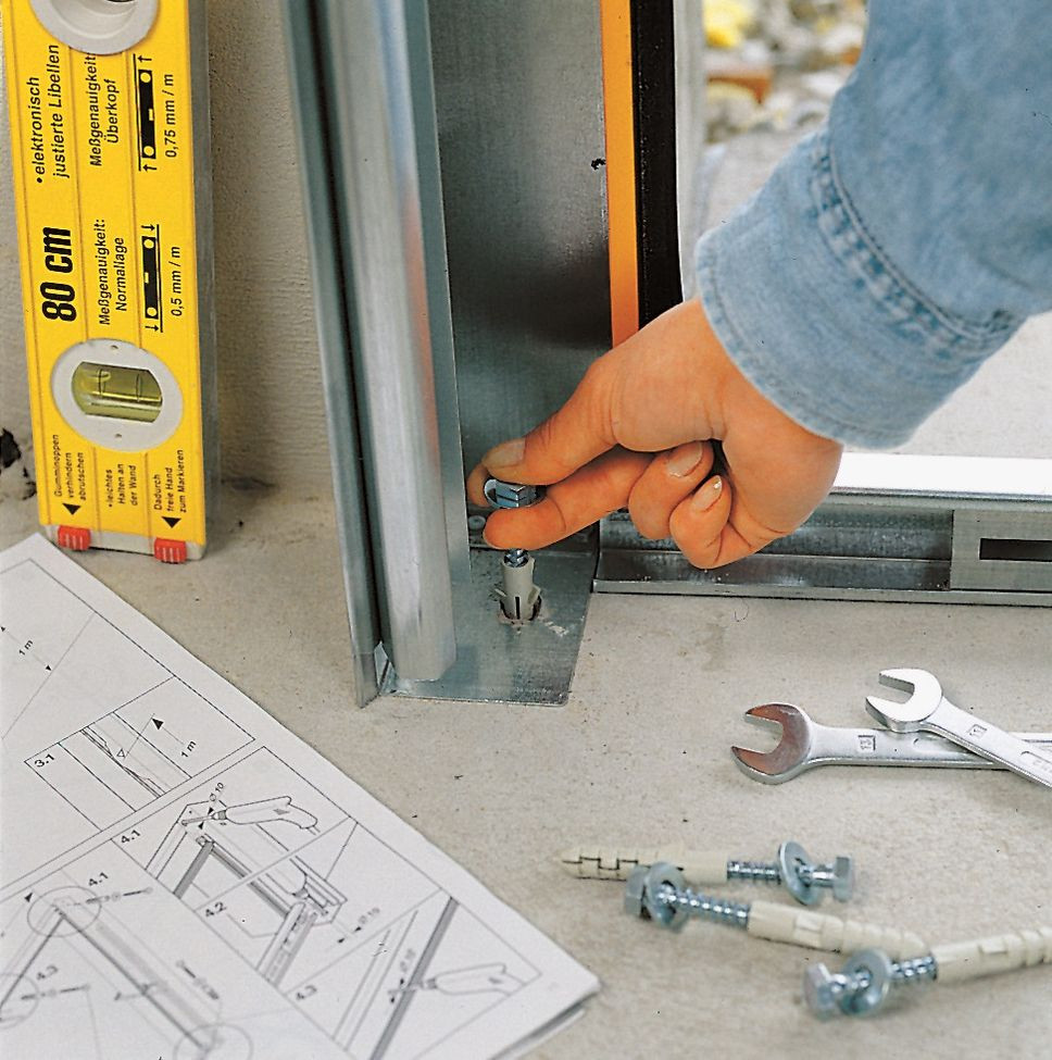 Montaż bramy segmentowej: Do podłogi bramę przytwierdza się za pomocą śrub i dybli