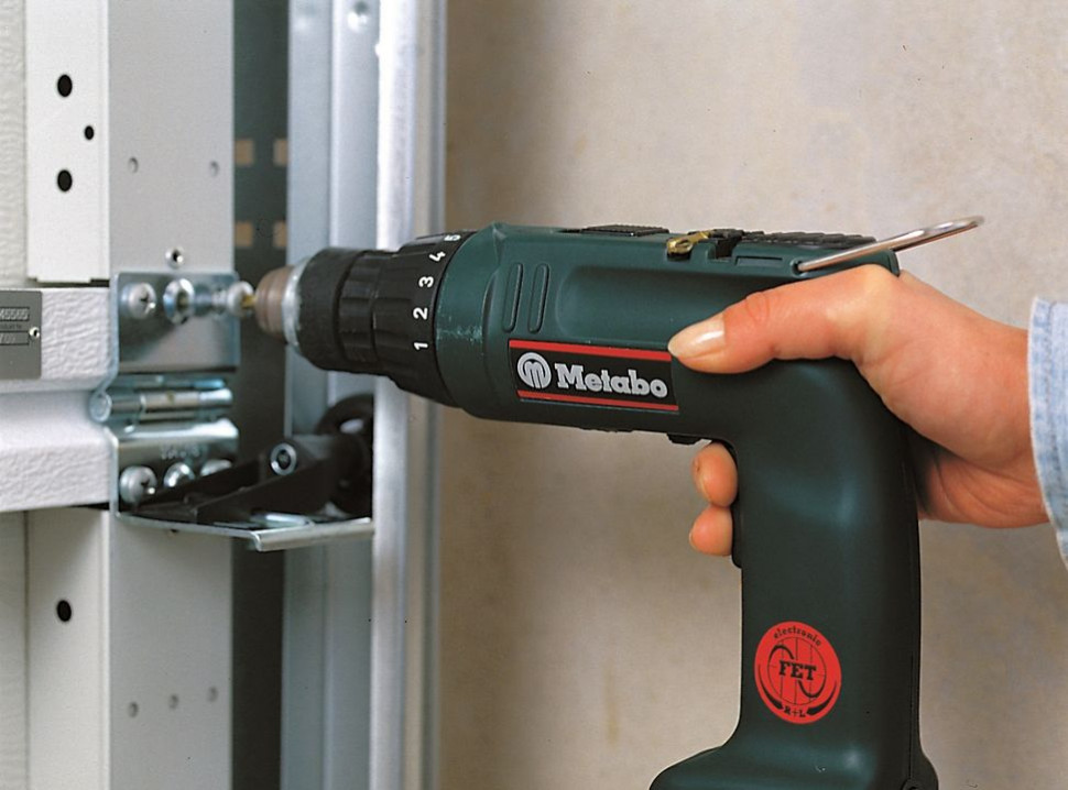 Montaż bramy segmentowej: Poszczególne segmenty łączy się za pomocą blachowkrętów i odpowiednio ukształtowanych zawiasów w miejscu, w którym znajdują się wcześniej przygotowane fabrycznie otwory