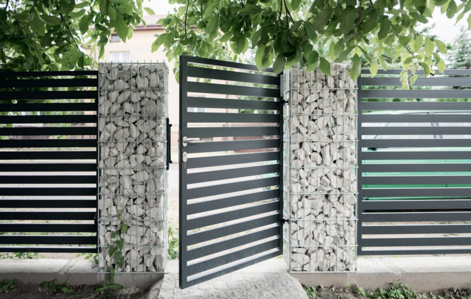 Furtka w nowoczesnym stylu zamontowana w ogrodzeniu z gabionów