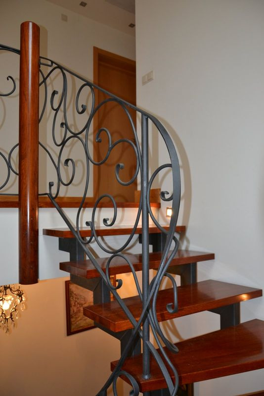 Fragmenty ozdobnej kutej balustrady. Balustrada na poddaszu ma wysokość 95 cm, wzdłuż schodów - 90 cm