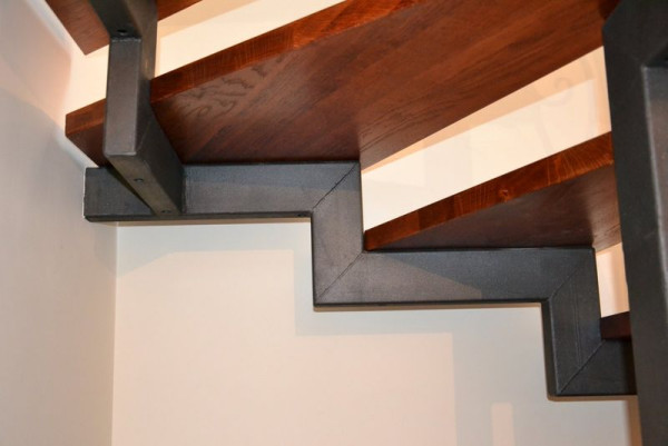 Stalową konstrukcję schodów podparto poprzeczną stalową belką, z dwóch stron zakotwioną w ścianach