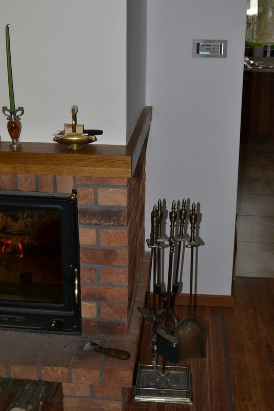 Na ścianie przy kominku umieszczono regulator kominkowy