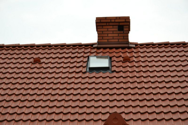 Wyłaz dachowy umieszczono blisko kalenicy i komina w salonie