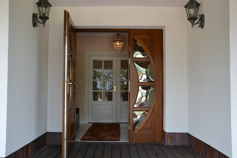 Szersza część drzwi jest otwierana, węższa zamontowana na stałe. W głębi oszklone drzwi w wiatrołapie