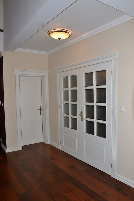 Dwuskrzydłowe drzwi do wiatrołapu są częściowo oszklone. Szyby matowe z przezroczystym fazowaniem