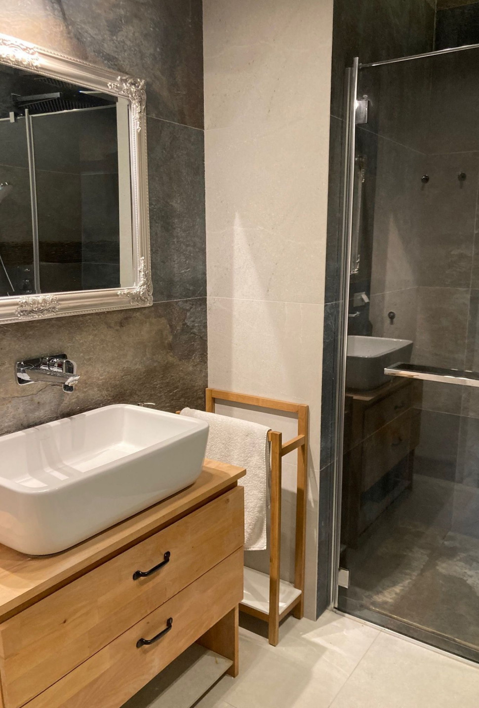 Nad nablatową umywalką zamontowano podtynkową chromowaną baterię, lustro, kinkiet