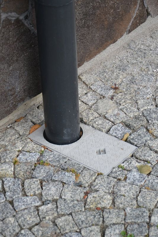 Rura spustowa z koszyczkami rewizyjnymi odprowadza wodę do gruntu przez rury drenujące