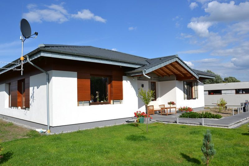 Niski kopertowy dach pokrywa płaska dachówka cementowa o geometrycznym kształcie